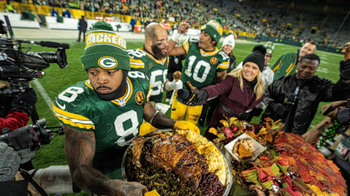 Green Bay Packers running back Josh Jacobs (8) carries a turkey back to the locker room after beating the Miami Dolphins.