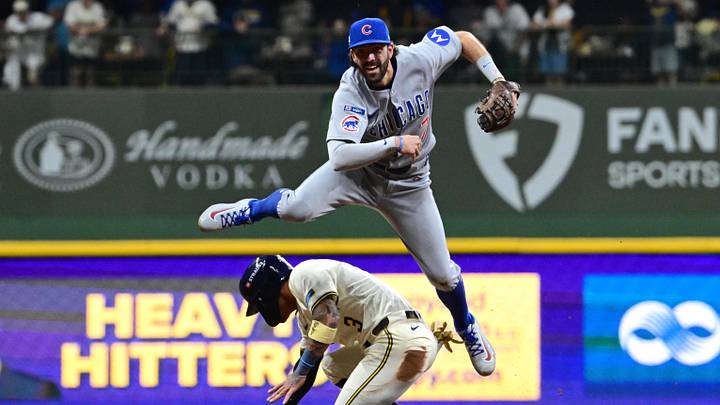 Oct 11, 2025; Milwaukee, Wisconsin, USA; Chicago Cubs shortstop Dansby Swanson (7) throws to first on a double play against Milwaukee Brewers shortstop Joey Ortiz (3) in the third inning during game five of the NLDS round for the 2025 MLB playoffs at American Family Field. Mandatory Credit: Benny Sieu-Imagn Images