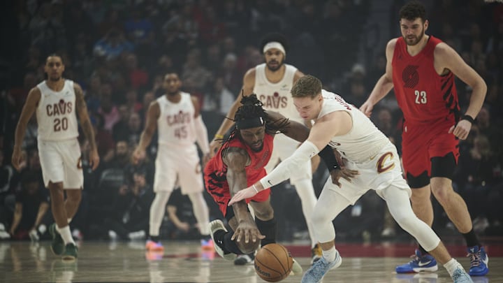 Feb 1, 2026; Portland, Oregon, USA; Portland Trail Blazers forward Jerami Grant (9), left, and Cleveland Cavaliers guard Sam Merrill (5) scramble for a loose ball during the first half at Moda Center. Mandatory Credit: Troy Wayrynen-Imagn Images