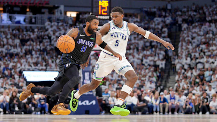 Dallas Mavericks guard Kyrie Irving (11) controls the ball against Minnesota Timberwolves guard Anthony Edwards.
