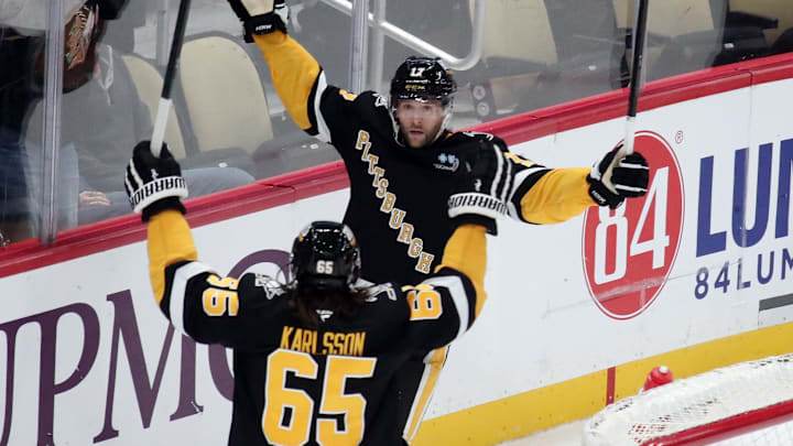 Dec 3, 2024; Pittsburgh, Pennsylvania, USA;  Pittsburgh Penguins right wing Bryan Rust (17) celebrates his game winning goal with defenseman Erik Karlsson (65) in overtime against the Florida Panthers at PPG Paints Arena. Mandatory Credit: Charles LeClaire-Imagn Images