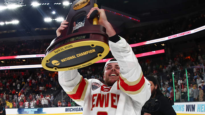 Denver defenseman Boston Buckberger holds the 2026 national championship trophy in college hockey at the Frozen Four in Las Vegas. 