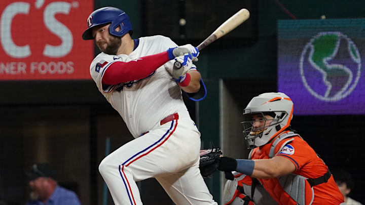 May 15, 2025; Arlington, Texas, USA; Texas Rangers first baseman Jake Burger (21) hits a single during the eighth inning against the Houston Astros at Globe Life Field. 