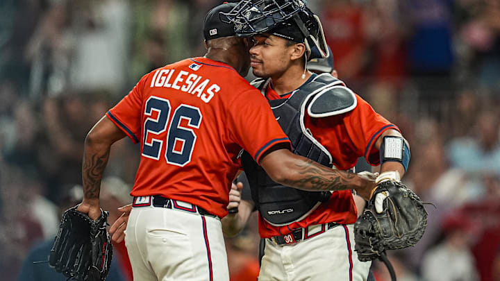  Atlanta Braves relief pitcher Raisel Iglesias (26) reacts with catcher Drake Baldwin (30) after the Braves defeated the New York Yankees at Truist Park.
