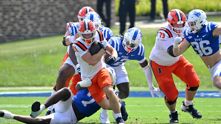 Sep 6, 2025; Durham, North Carolina, USA;  Illinois Fighting Illini kicker Lucas Osada (27) runs against Duke Blue Devils defensive end Vincent Anthony Jr. (7) during the first quarter at Wallace Wade Stadium. Mandatory Credit: Zachary Taft-Imagn Images