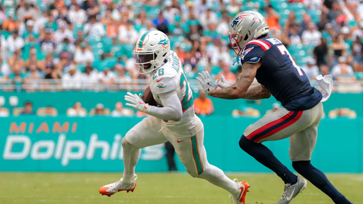 Sep 14, 2025; Miami Gardens, Florida, USA; Miami Dolphins running back De'Von Achane (28) runs with the football against New England Patriots cornerback Carlton Davis III (7) during the third quarter at Hard Rock Stadium. Mandatory Credit: Sam Navarro-Imagn Images Sep 14, 2025; Miami Gardens, Florida, USA; Miami Dolphins running back De'Von Achane (28) runs with the football against New England Patriots cornerback Carlton Davis III (7) during the third quarter at Hard Rock Stadium. Mandatory Credit: Sam Navarro-Imagn Images