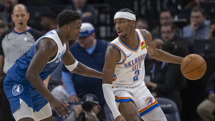Jan 20, 2024; Minneapolis, Minnesota, USA; Oklahoma City Thunder guard Shai Gilgeous-Alexander (2) looks to pass the ball as Minnesota Timberwolves guard Anthony Edwards (5) plays defense in the second half at Target Center. Mandatory Credit: Jesse Johnson-Imagn Images