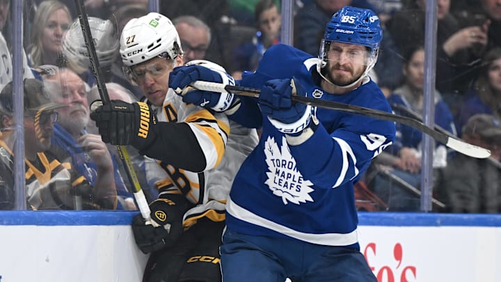 Nov 8, 2025; Toronto, Ontario, CAN;  Toronto Maple Leafs defenseman Oliver Ekman-Larsson (95) bodychecks Boston Bruins defenseman Hampus Lindholm (27) in the first period at Scotiabank Arena. Mandatory Credit: Dan Hamilton-Imagn Images