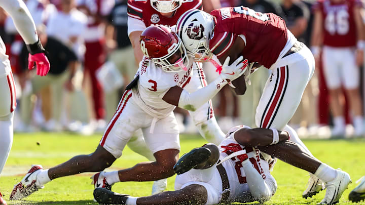 Oklahoma defensive back Robert Spears-Jennings and linebacker Kip Lewis combine to make a tackle against South Carolina.