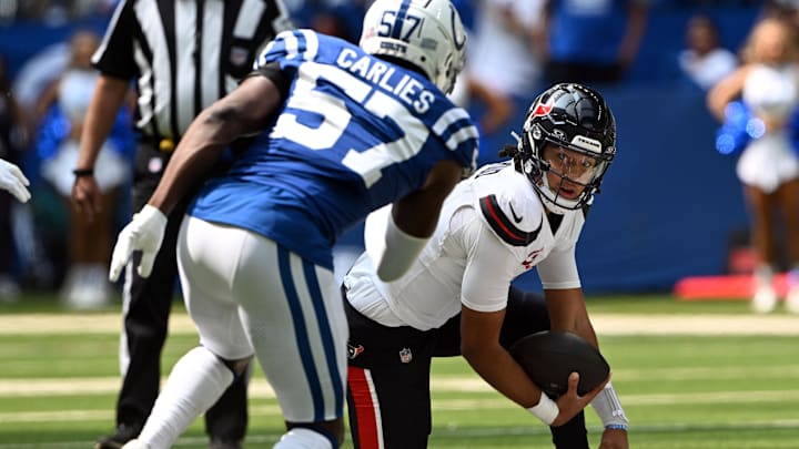 Sep 8, 2024; Indianapolis, Indiana, USA; Houston Texans quarterback C.J. Stroud (7) stumbles in front of Indianapolis Colts linebacker Jaylon Carlies (57) during the first quarter at Lucas Oil Stadium. Mandatory Credit: Marc Lebryk-Imagn Images