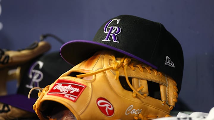 Jun 15, 2023; Atlanta, Georgia, USA; A detailed view of a Colorado Rockies hat and glove on the bench against the Atlanta Braves in the ninth inning at Truist Park. Mandatory Credit: Brett Davis-Imagn Images