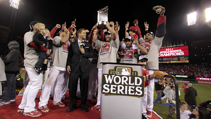 Oct 28, 2011; St. Louis, MO, USA; St. Louis Cardinals players celebrate with the commissioners trophy on the podium after defeating the Texas Rangers 6-2 in game seven of the 2011 World Series at Busch Stadium.  The Cardinals won the series four games to three. Mandatory Credit: Charlie Riedel/Pool Photo via Imagn Images