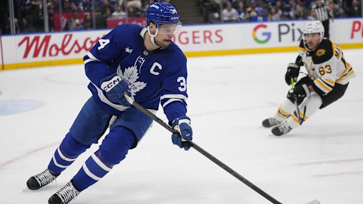 Jan 4, 2025; Toronto, Ontario, CAN; Toronto Maple Leafs forward Auston Matthews (34) carries the puck as Boston Bruins forward Brad Marchand (63) closes in during the second period at Scotiabank Arena. Mandatory Credit: John E. Sokolowski-Imagn Images