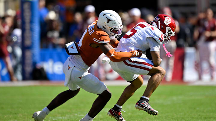 Oct 11, 2025; Dallas, Texas, USA; Texas Longhorns defensive back Jelani McDonald (4) tackles Oklahoma Sooners wide receiver Isaiah Sategna III (5) during the game between the Texas Longhorns and the Oklahoma Sooners at the Cotton Bowl. Mandatory Credit: Jerome Miron-Imagn Images