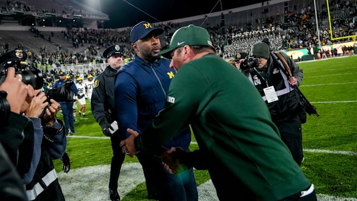 Michigan State's head coach Jonathan Smith, right, shakes hands with Michigan's head coach Sherrone Moore