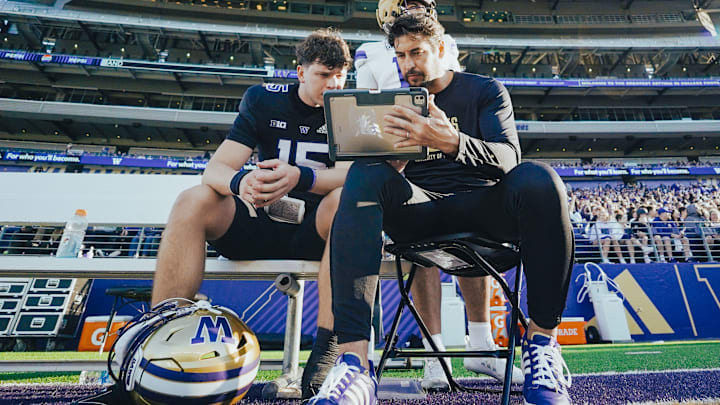 Kai Horton sits with former NFL QB JP Losman and goes over a play on an iPad in 2025.