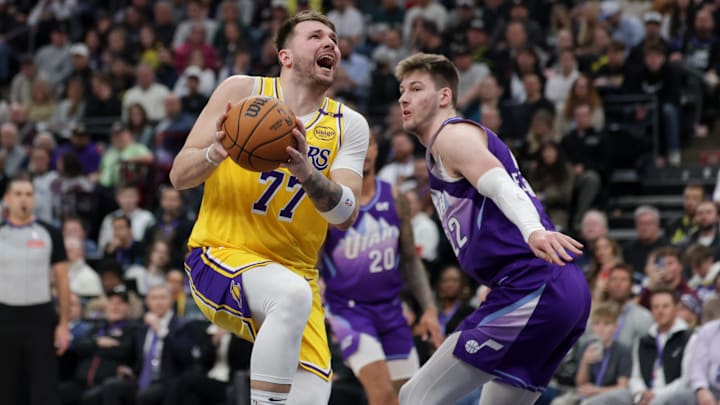Feb 12, 2025; Salt Lake City, Utah, USA;  Los Angeles Lakers guard Luka Doncic (77) is fouled by Utah Jazz forward Kyle Filipowski (22) during the second quarter at Delta Center. Mandatory Credit: Chris Nicoll-Imagn Images