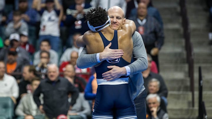 Penn State wrestling coach Cael Sanderson hugs Nittany Lions wrestler Carter Starocci after Starocci won the 2023 NCAA title.