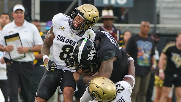 Sep 28, 2024; Orlando, Florida, USA; UCF Knights quarterback KJ Jefferson (1) is tackled by Colorado Buffaloes cornerback DJ McKinney (8) and safety Carter Stoutmire (23) during the second half at FBC Mortgage Stadium.