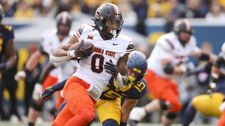 Oct 21, 2023; Morgantown, West Virginia, USA; Oklahoma State Cowboys running back Ollie Gordon II (0) runs for a touchdown during the first quarter against the West Virginia Mountaineers at Mountaineer Field at Milan Puskar Stadium. Mandatory Credit: Ben Queen-Imagn Images