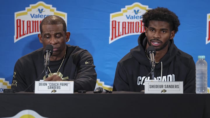 Dec 28, 2024; San Antonio, TX, USA; Colorado Buffaloes head coach Deion Sanders and quarterback Shedeur Sanders (2) talk with the media after the game against the Brigham Young Cougars at Alamodome. Mandatory Credit: Troy Taormina-Imagn Images