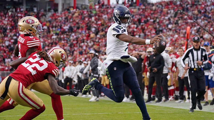 Nov 17, 2024; Santa Clara, California, USA; Seattle Seahawks quarterback Geno Smith (7) scores a rushing touchdown past San Francisco 49ers cornerback Isaac Yiadom (22) to win the game in the fourth quarter at Levi's Stadium. Mandatory Credit: David Gonzales-Imagn Images
