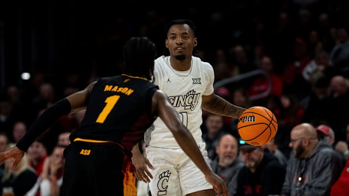 Cincinnati Bearcats guard Day Day Thomas (1) handles the ball as Arizona State Sun Devils guard Alston Mason (1) defends in the second half of the NCAA basketball game at Fifth Third Arena in Cincinnati on Saturday, January 18, 2025.