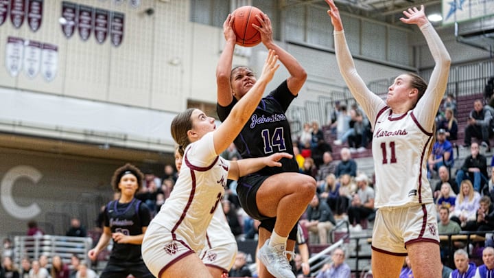 Johnston's Ari Phillips (14) drives past her Dowling defenders on her way to the paint on Friday, Jan. 24, 2025, at Dowling Catholic High School.