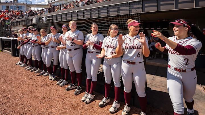 Cori McMillan runs out of the dugout to run down the line, giving her teammates high-fives. Cori McMillan runs out of the dugout to run down the line, giving her teammates high-fives.