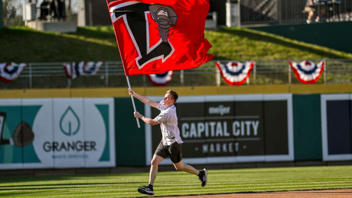 The Lugnuts flag is paraded around the bases before the home opener against the Great Lake Loons on Tuesday, April 9, 2024, at Jackson Field in Lansing. The Lugnuts flag is paraded around the bases before the home opener against the Great Lake Loons on Tuesday, April 9, 2024, at Jackson Field in Lansing.