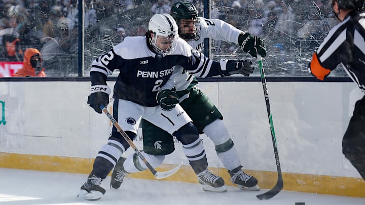 Jan 31, 2026; State College, PA, USA; Penn State Nittany Lions defenseman Carter Schade (2) and Michigan State Spartans forward Shane Vansaghi (23) battle for the puck during the second period at Beaver Stadium. Mandatory Credit: Matthew O'Haren-Imagn Images