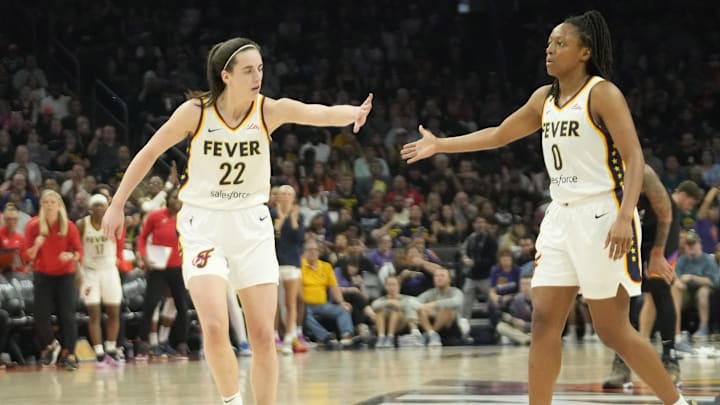 Jun 30, 2024; Phoenix, Ariz., U.S.; Indiana Fever guard Caitlin Clark (22) slaps hands with guard Kelsey Mitchell (0) during the third quarter against the Phoenix Mercury at Footprint Center. Mandatory Credit: Michael Chow-Arizona Republic