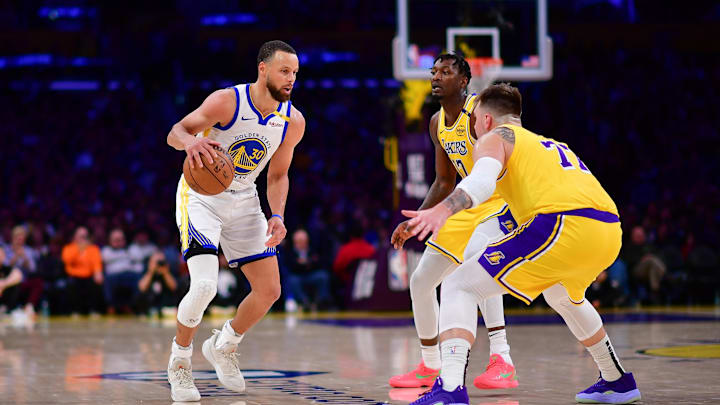 Golden State Warriors guard Stephen Curry (30) controls the ball against Los Angeles Lakers forward Dorian Finney-Smith (17) and guard Luka Doncic (77) during the second half at Crypto.com Arena.