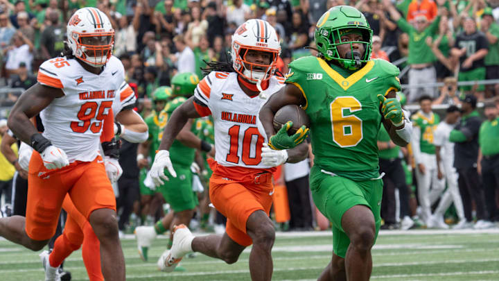 Oregon’s Noah Whittington, right, break for the end zone for the first touchdown of the game against Oklahoma State during the first quarter at Autzen.