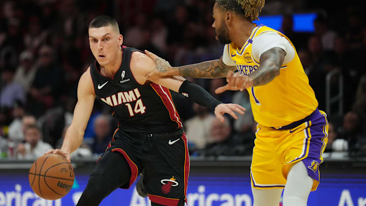 Dec 4, 2024; Miami, Florida, USA;  Miami Heat guard Tyler Herro (14) drives past Los Angeles Lakers guard D'Angelo Russell (1) in the first half at Kaseya Center. Mandatory Credit: Jim Rassol-Imagn Images