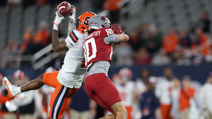 Syracuse defensive back Alijah Clark intercepts the ball against Washington State wide receiver Branden Ganashamoorthy.