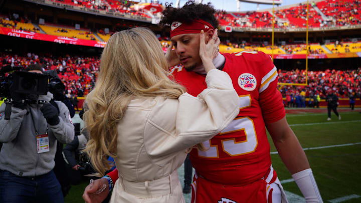 Kansas City Chiefs quarterback Patrick Mahomes (15) kisses his wife Brittany Mahomes before a 2025 AFC divisional round game against the Houston Texans at GEHA Field at Arrowhead Stadium.
