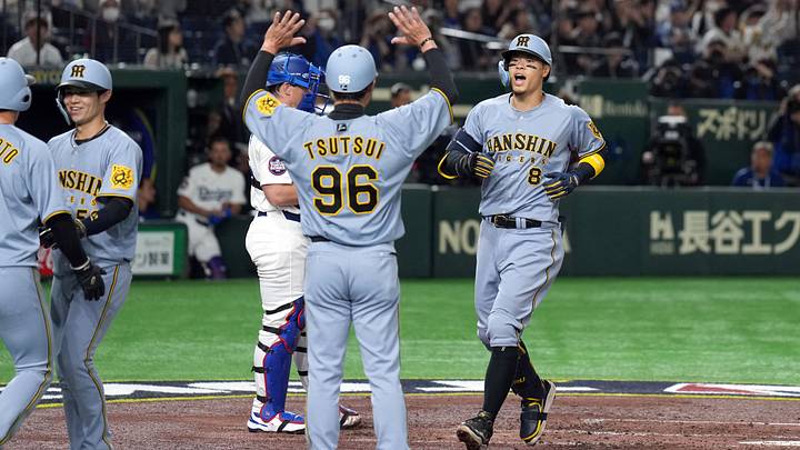 Mar 16, 2025; Bunkyo, Tokyo, Japan; Hanshin Tigers third baseman Teruaki Sato (8) celebrates with teammates after hitting a home run against the Los Angeles Dodgers during the fourth inning at Tokyo Dome. Mandatory Credit: Darren Yamashita-Imagn Images Mar 16, 2025; Bunkyo, Tokyo, Japan; Hanshin Tigers third baseman Teruaki Sato (8) celebrates with teammates after hitting a home run against the Los Angeles Dodgers during the fourth inning at Tokyo Dome. Mandatory Credit: Darren Yamashita-Imagn Images