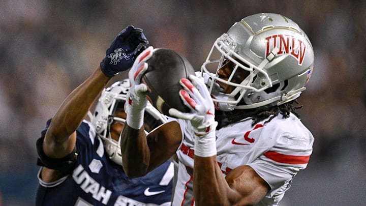 UNLV Rebels wide receiver Ricky White III (11) catches a touchdown pass in front of Utah State Aggies cornerback Avante Dickerson (17) in the first half at Merlin Olsen Field at Maverik Stadium. 