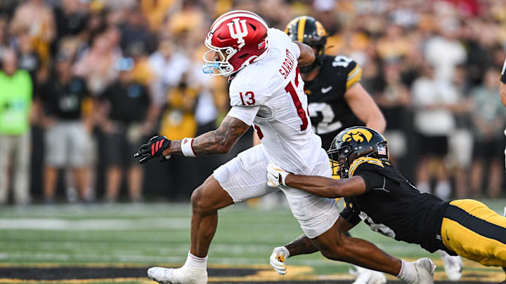 Sep 27, 2025; Iowa City, Iowa, USA; Indiana Hoosiers wide receiver Elijah Sarratt (13) breaks the tackle of Iowa Hawkeyes defensive back Deshaun Lee (8) and runs for the end zone on a 49-yard touchdown reception late during the fourth quarter at Kinnick Stadium. Mandatory Credit: Jeffrey Becker-Imagn Images
