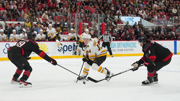 Oct 27, 2026; Raleigh, North Carolina, USA; Boston Bruins center James Hagens (44) tries to skate with the puck past Carolina Hurricanes defenseman K'andre Miller (19) and defenseman Jalen Chatfield (5) during the second period at Lenovo Center. Mandatory Credit: James Guillory-Imagn Images Oct 27, 2026; Raleigh, North Carolina, USA; Boston Bruins center James Hagens (44) tries to skate with the puck past Carolina Hurricanes defenseman K'andre Miller (19) and defenseman Jalen Chatfield (5) during the second period at Lenovo Center. Mandatory Credit: James Guillory-Imagn Images