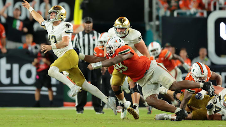 Aug 31, 2025; Miami Gardens, Florida, USA; Notre Dame Fighting Irish quarterback CJ Carr (13) throws the ball to avoid a sack against the Miami Hurricanes at Hard Rock Stadium. Mandatory Credit: Sam Navarro-Imagn Images