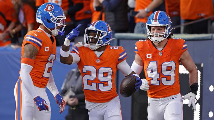 Jan 4, 2026; Denver, Colorado, USA; Denver Broncos cornerback Ja'quan McMillian (29) celebrates with teammates after scoring a touchdown against the Los Angeles Chargers during the first half at Empower Field at Mile High. 
