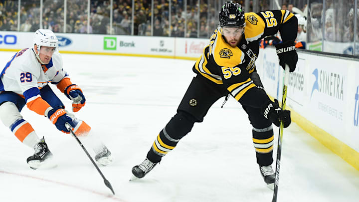 Jan 5, 2025; Boston, Massachusetts, USA; Boston Bruins right wing Justin Brazeau (55) controls the puck while New York Islanders center Brock Nelson (29) defends during the first period at TD Garden. Mandatory Credit: Bob DeChiara-Imagn Images
