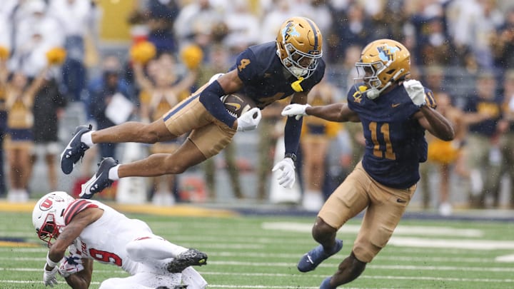 Sep 27, 2025; Morgantown, West Virginia, USA; West Virginia Mountaineers wide receiver Cam Vaughn (4) jumps over Utah Utes cornerback Elijah Davis (9) during the first quarter at Milan Puskar Stadium. Mandatory Credit: Ben Queen-Imagn Images
