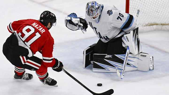 Mar 30, 2025; Chicago, Illinois, USA;  Chicago Blackhawks center Frank Nazar (91) shoots against Utah Hockey Club goaltender Karel Vejmelka (70) during the second period at United Center. Mandatory Credit: Matt Marton-Imagn Images