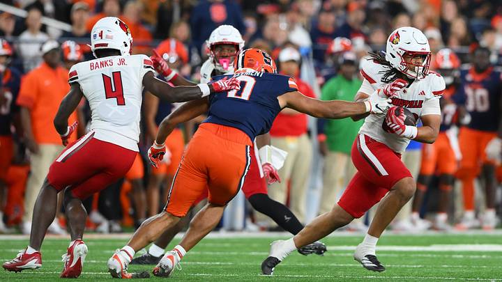 Oct 17, 2026; Syracuse, New York, USA; Louisville Cardinals linebacker Cameron White (right) returns his interception past the reach of Syracuse Orange tight end David Clement (0) during the second half at the JMA Wireless Dome. Mandatory Credit: Rich Barnes-Imagn Images Oct 17, 2026; Syracuse, New York, USA; Louisville Cardinals linebacker Cameron White (right) returns his interception past the reach of Syracuse Orange tight end David Clement (0) during the second half at the JMA Wireless Dome. Mandatory Credit: Rich Barnes-Imagn Images