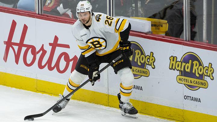 Oct 27, 2025; Ottawa, Ontario, CAN; Boston Bruins defenseman Andrew Peeke (26) controls the puck in the third period against the  Ottawa Senators at the Canadian Tire Centre. Mandatory Credit: Marc DesRosiers-IMAGN Images