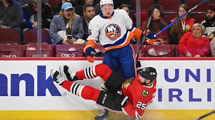Jan 19, 2024; Chicago, Illinois, USA; Chicago Blackhawks defensman Jarred Tinordi (25) falls to the ice after checking New York Islanders forward Julien Gauthier (16) in the second period at United Center. Mandatory Credit: Jamie Sabau-Imagn Images Jan 19, 2024; Chicago, Illinois, USA; Chicago Blackhawks defensman Jarred Tinordi (25) falls to the ice after checking New York Islanders forward Julien Gauthier (16) in the second period at United Center. Mandatory Credit: Jamie Sabau-Imagn Images