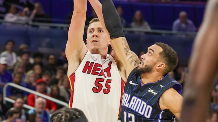 Dec 26, 2024; Orlando, Florida, USA; Miami Heat forward Duncan Robinson (55) shoots against Orlando Magic guard Trevelin Queen (12) during the second quarter at Kia Center. Mandatory Credit: Mike Watters-Imagn Images
